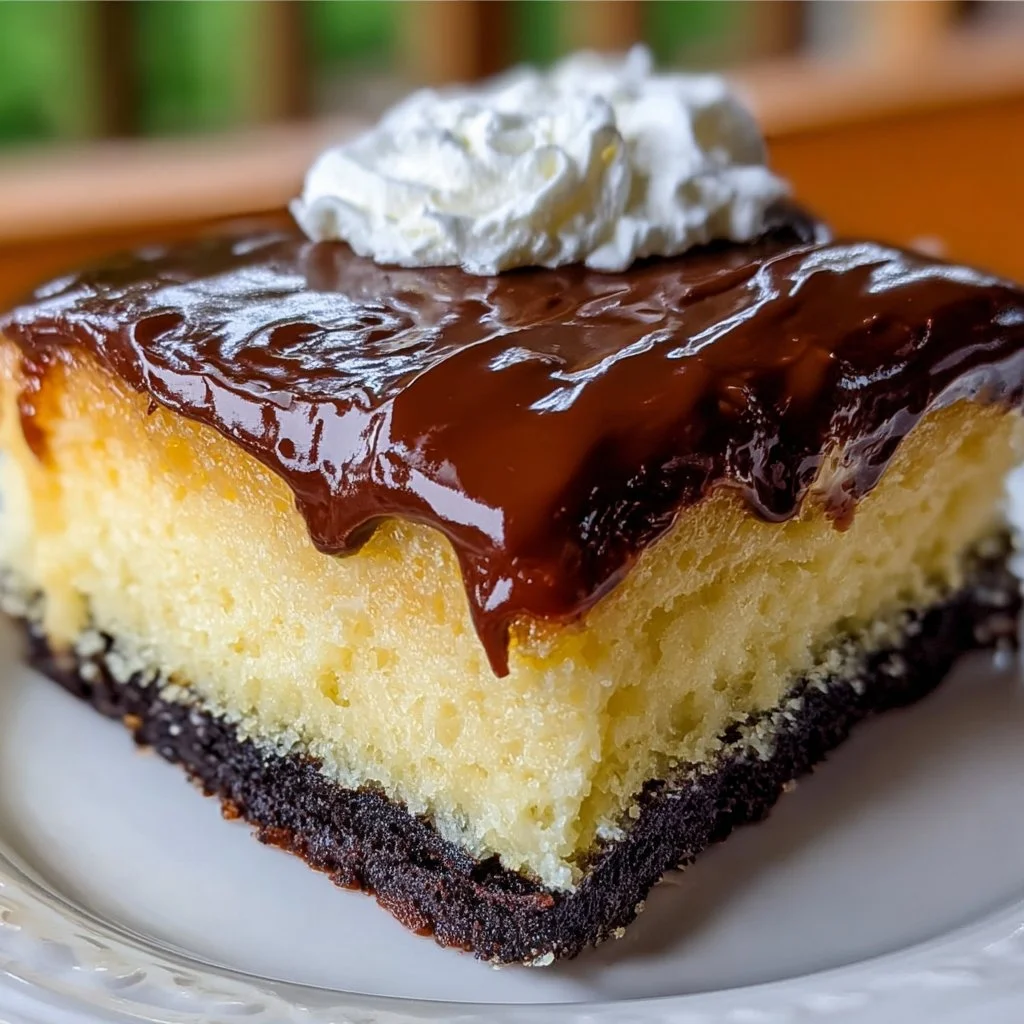 Delicious slice of Boston Cream Poke Cake topped with chocolate frosting and whipped cream