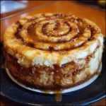 Slice of Cinnamon Roll Honeybun Cheesecake topped with swirl frosting